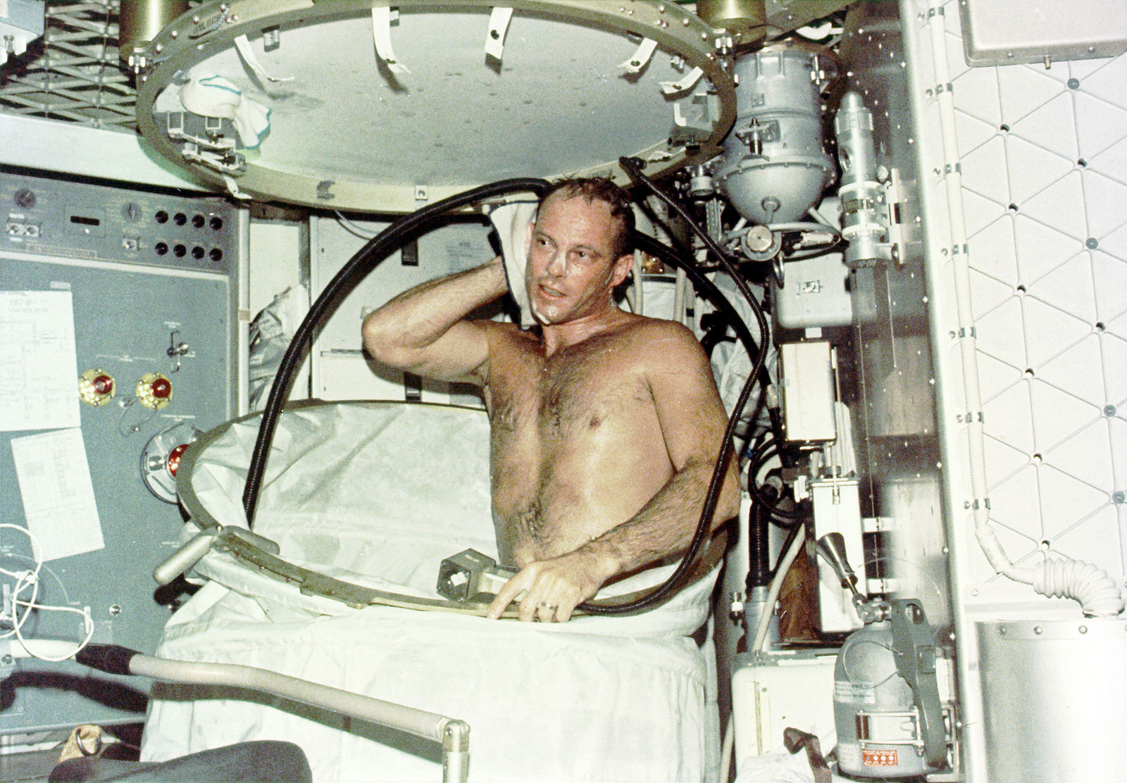 Photo: Astronaut taking a hot bath in the crew quarters of the Orbital Workshop (OWS) of the Skylab space station cluster in Earth orbit